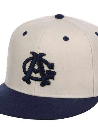 The Ebbets Field Chicago American Giants NLB Ballpark Fitted Ballcap features a cream color with a navy brim and embroidered navy and gold interlocking AC logo, plus ventilation holes on top.