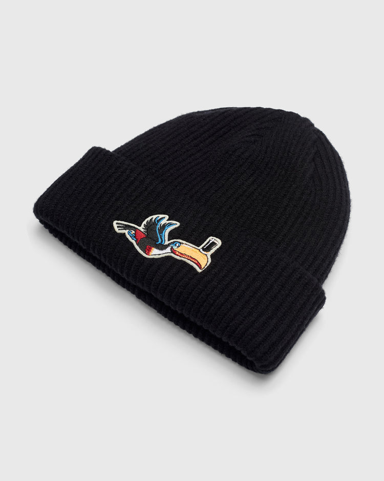 Black rib-knit Guinness Flying Toucan Felt Patch Ribbed Beanie with a felt patch of a flying toucan holding a top hat in its beak.