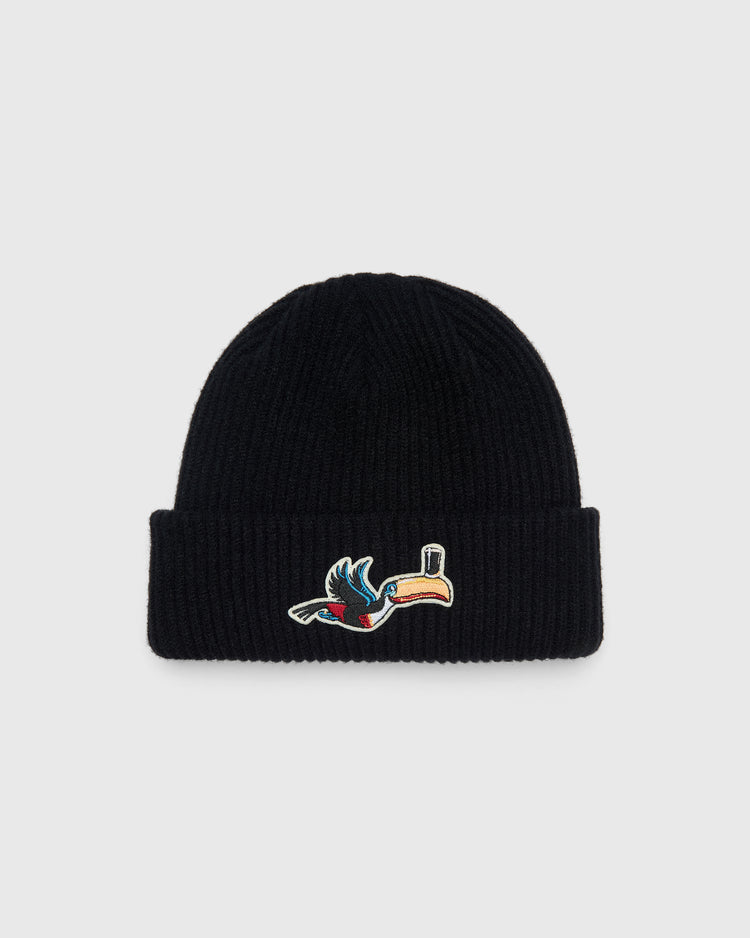 Black rib-knit Guinness Flying Toucan Felt Patch Ribbed Beanie featuring a felt patch of a toucan balancing a glass on its beak.