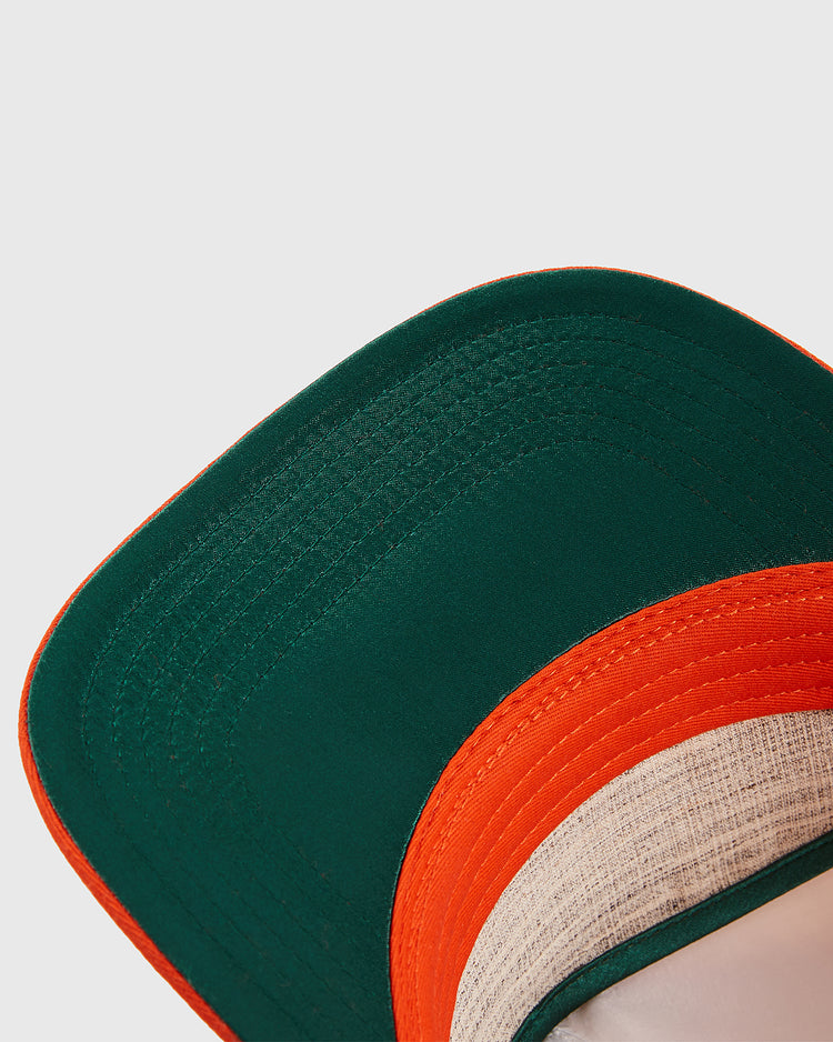 Close-up of the Los Angeles Aztecs A-Frame Cotton Twill Ballcap by Ebbets Field, showing its dark green brim with bright orange edge and vintage-style stitching, inspired by classic North American Soccer League designs.
