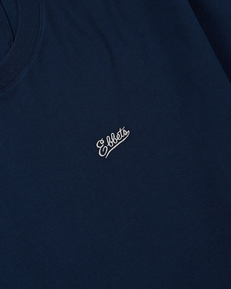 A close-up of the Ebbets Field Portland Beavers Ebbets Tee with Back Print in navy blue, featuring Ebbets embroidered in white cursive lettering on the chest.