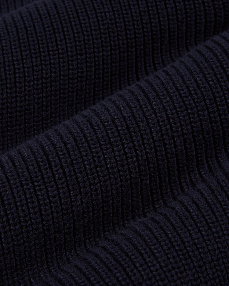 Close-up of the Ebbets Field NOTRE DAME VARSITY CARDIGAN Navy shows its dark navy ribbed knit fabric with raised vertical ridges, highlighting the textured pattern and suggesting softness and flexibility.