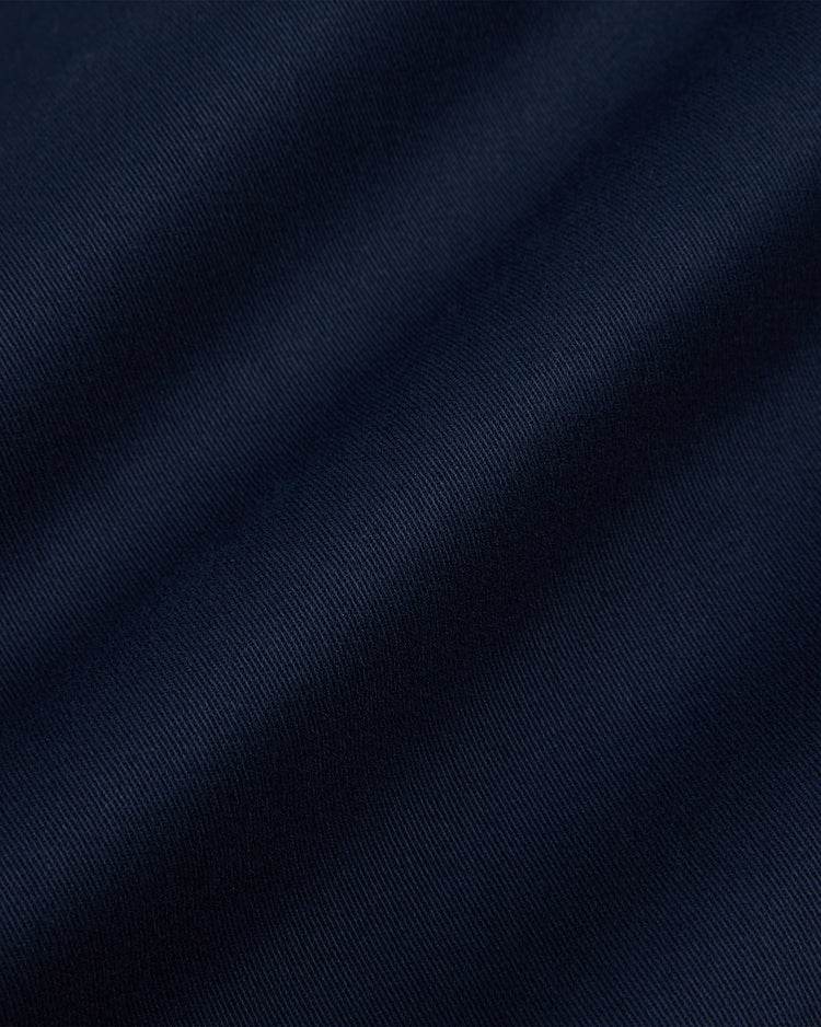 Close-up of the Ebbets Field YALE GROUNDS CREW JACKET in Navy, showing dark blue fabric with soft diagonal folds and a smooth, slightly textured surface.
