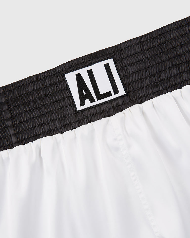 Close-up of the waistband from Ebbets Field’s Muhammad Ali Vintage Inspired Boxing Trunks, featuring a black elastic band and white patch with 