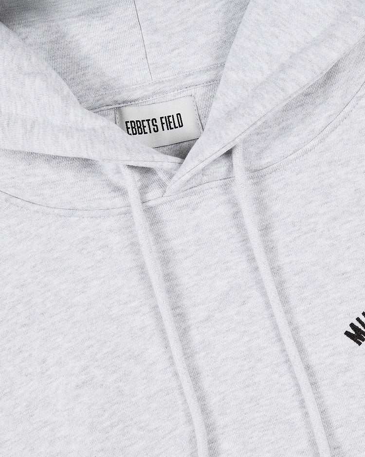 A close-up of a light grey Muhammad Ali Chest Embroidered Heavyweight Cotton Terry Pullover Hoodie by Ebbets Field, featuring drawstrings and an inside label—part of the iconic Thrilla in Manila collection.