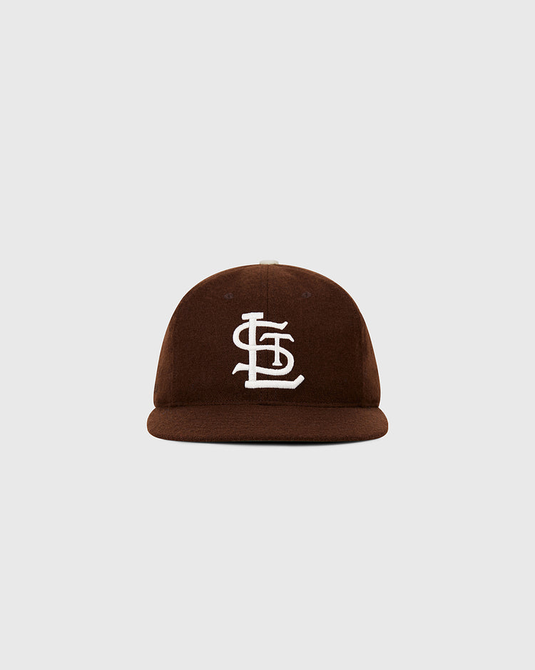 The Ebbets Field St. Louis Browns 1953 MLB Authentic Wool Ballcap features a brown flat brim, white interlocking STL logo, and is part of the Decade of Change Collection, shown against a light gray background.