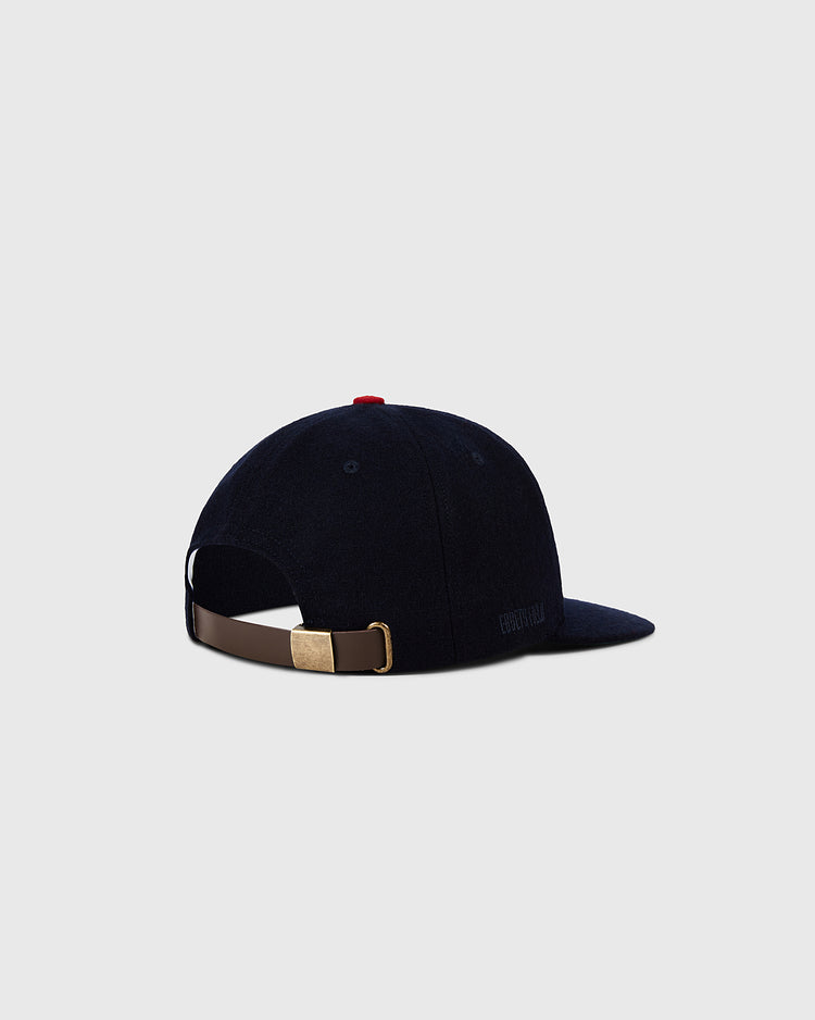 A Minnesota Twin 1961 MLB Authentic Wool Ballcap by Ebbets Field, shown from the back with an adjustable brown strap, brass buckle, red top button, and plain light gray background. Part of the Decade of Change Collection.