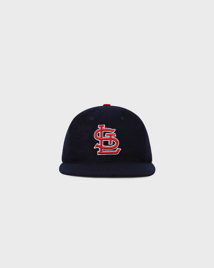 The Ebbets Field St. Louis Cardinals 1963 MLB Authentic Wool Ballcap, from the Decade of Change Collection, features a navy design with a red and white interlocking STL logo, inspired by the original 1963 on-field cap. Displayed on a light gray background.