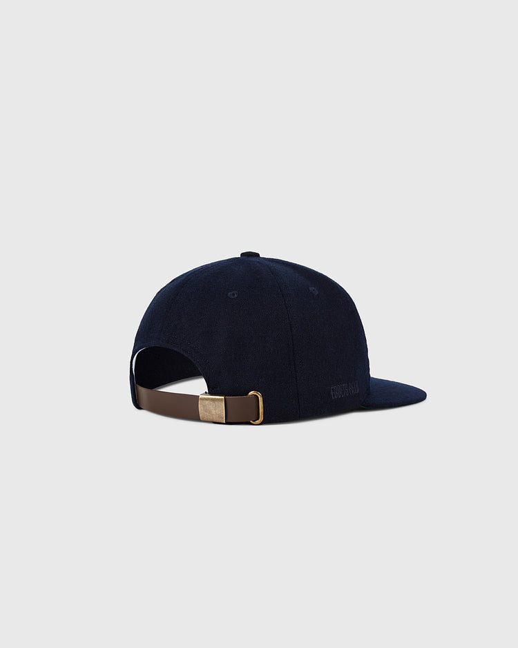 The Cleveland Indians 1958-1961 MLB Authentic Wool Ballcap by Ebbets Field is a navy vintage baseball hat with a curved brim, shown from the back. It has a brown adjustable strap and metal buckle, and sits against a light gray background.