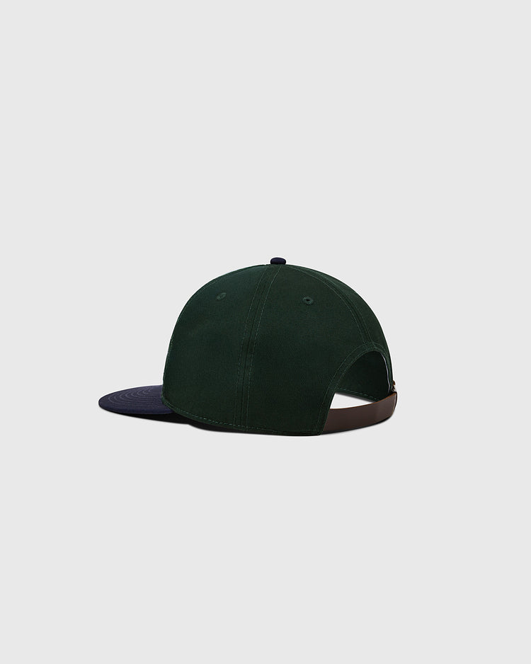 The Ebbets Field Flannels Ebbets Felt Script Cotton Twill Ballcap features dark green cotton twill, a navy brim, an adjustable brown leather strap, and is shown from the back against a plain light gray background.