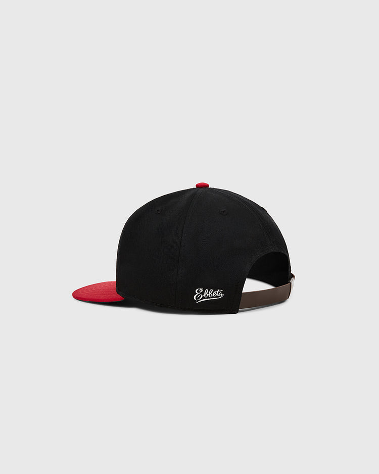 The Ebbets Field Birmingham Black Barons 1948 Cotton Twill Ballcap is black with a red brim, viewed from the back. It has an adjustable strap, white 