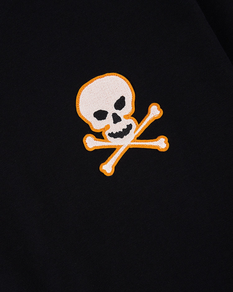 The Ebbets Field Sioux City Ghosts Embroidered Logo Short Sleeve Tee features a white skull and crossbones with an orange outline on black fabric, capturing the bold, vintage spirit of the legendary team.
