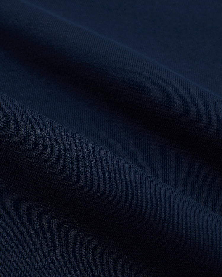 Close-up of the Ebbets Field USA 1960 Heavyweight Cotton Terry Pullover Hoodie in dark navy, highlighting its ribbed knit texture, soft folds, and subtle shadows reminiscent of classic vintage hockey styles.