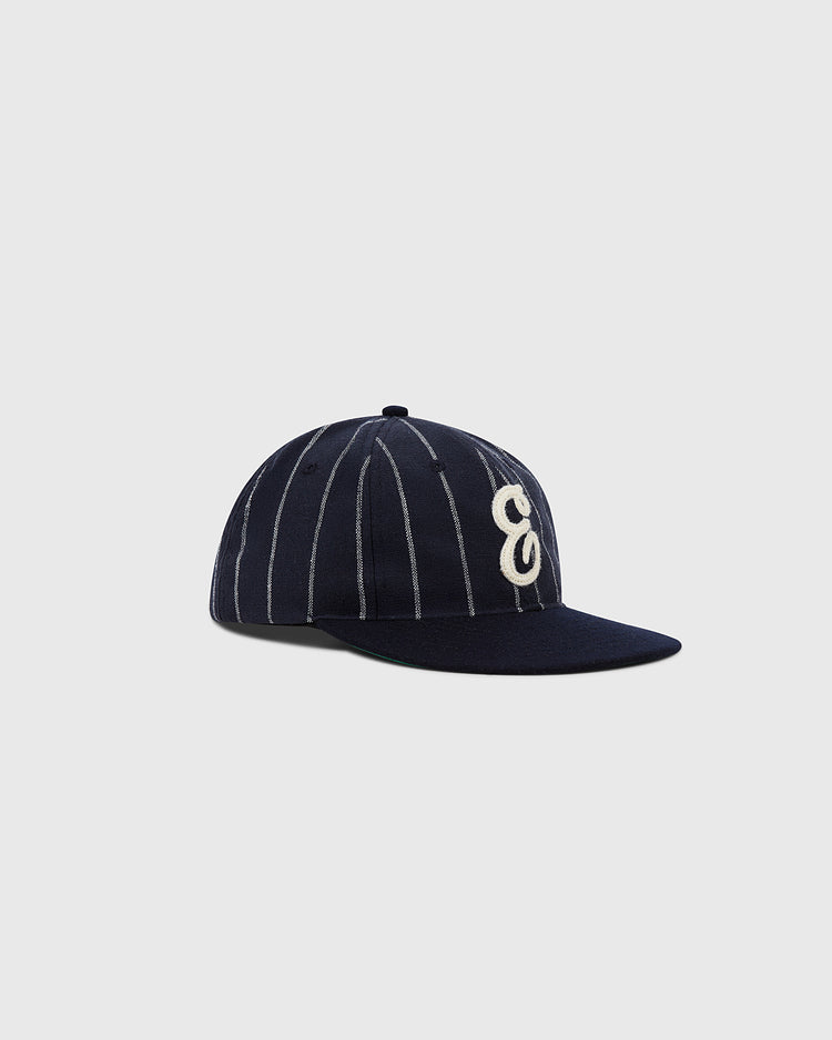 The Ebbets Field Ebbets Felt 'E' Wool Pinstripe Ballcap, made from wool broadcloth with white pinstripes and a bold embroidered letter E on the front, is shown against a plain light gray background.
