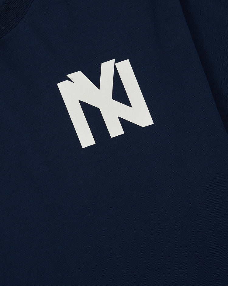 The Ebbets Field Brooklyn Eagles Logo Short Sleeve Tee Shirt is a navy blue tee featuring a bold white graphic with overlapping 