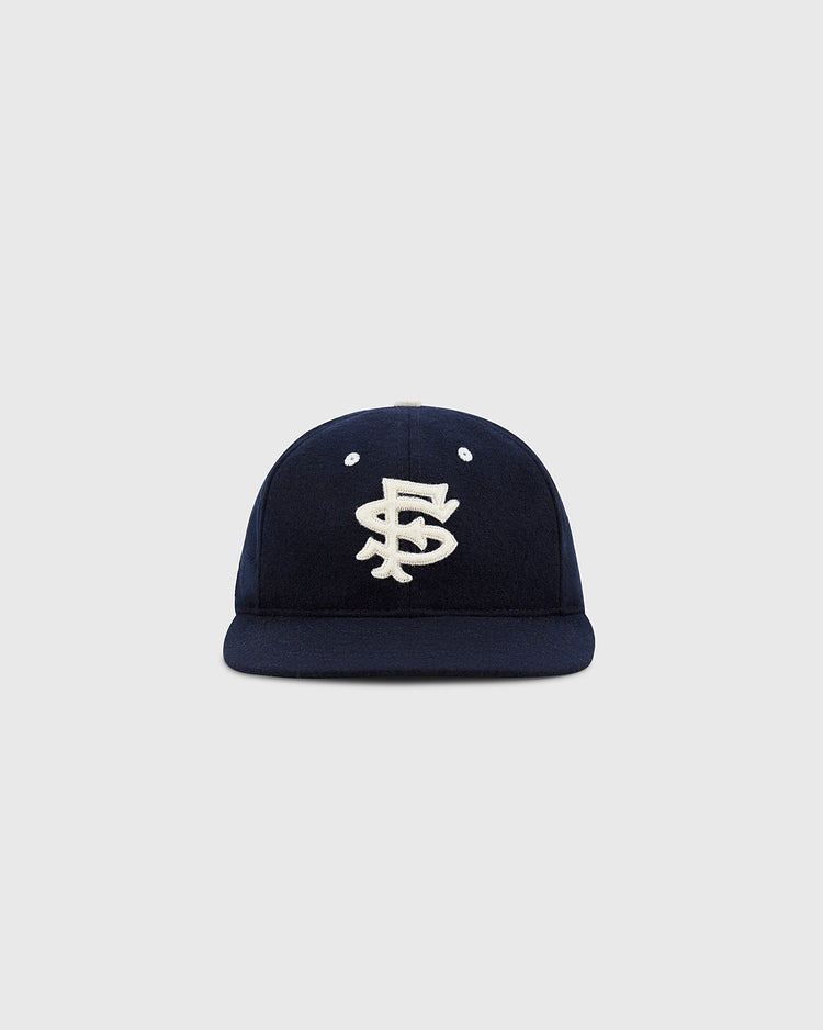 The EFF San Francisco Seals 1949 Authentic Wool Ballcap in navy features interlocking white embroidery on the front, echoing caps worn on post-war Japan tours, shown against a light gray background.
