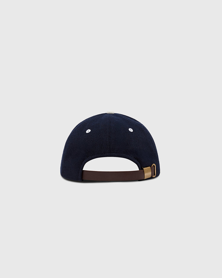 An EFF San Francisco Seals 1949 Authentic Wool Ballcap in navy, shown from the back with a brown adjustable strap and brass buckle, set against a light gray background—a tribute to Pacific Coast League heritage.