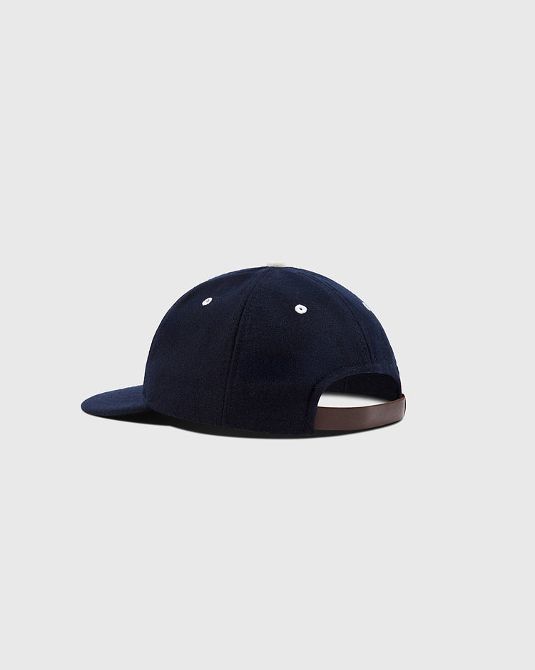 The EFF San Francisco Seals 1949 Authentic Wool Ballcap in navy, shown from the back with an adjustable strap and white stitched eyelets, recalls the classic style from the Pacific Coast League’s post-war Japan tour. Set on a light gray background.