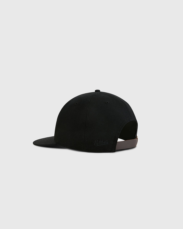 The Ebbets Field Black Cotton Twill Ballcap is shown from the back on a light grey background, highlighting its curved brim and adjustable strap for a timeless vintage style.
