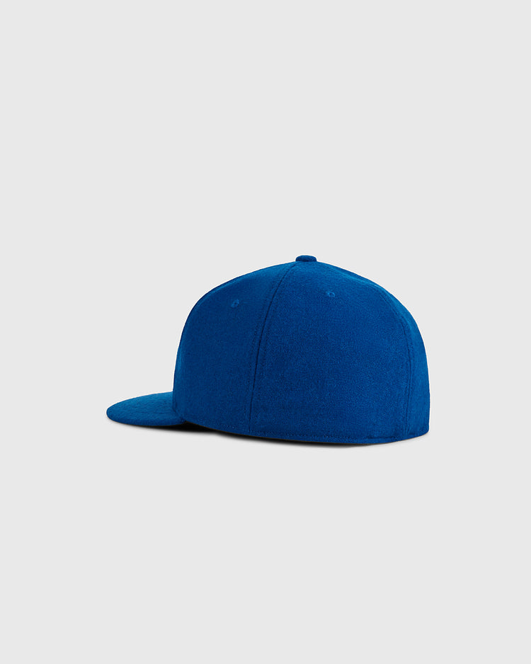 The Ebbets Field USA 1960 Wool Ballcap, shown from the back and side on a light gray background, features a blue vintage-inspired design with a flat bill and no visible logos or patterns.