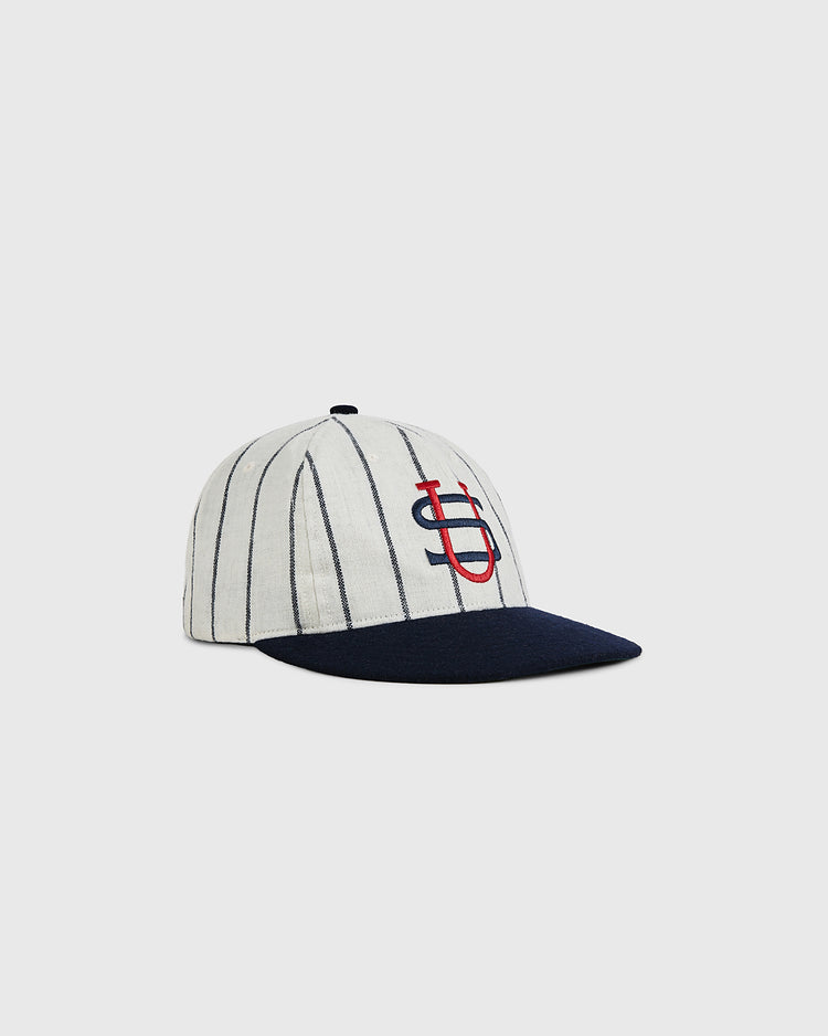 The Ebbets Field US Tour Of Japan 1934 Authentic Wool Ballcap features thin black pinstripes on white, a navy brim, and red intertwined S and D embroidery on the front, capturing classic 1934 baseball style against a simple background.