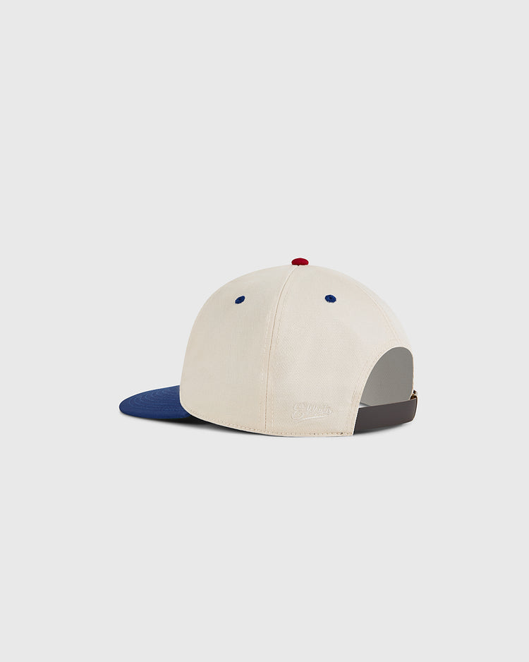 The Ebbets Field Puerto Rico 1958 National Team Cotton Twill Ballcap is cream-colored with a blue brim, brown adjustable strap, and blue and red accents, inspired by Roberto Clemente and the Puerto Rican national team. Shown from the back.