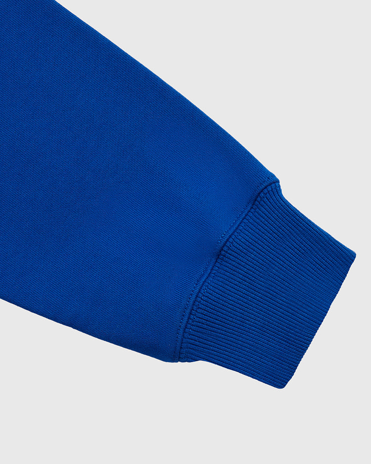 Close-up of the sleeve on the Santurce Cangrejeros Heavyweight Cotton Pullover Hoodie by Ebbets Field, highlighting the ribbed cuff and smooth heavyweight fabric against a plain light gray background.