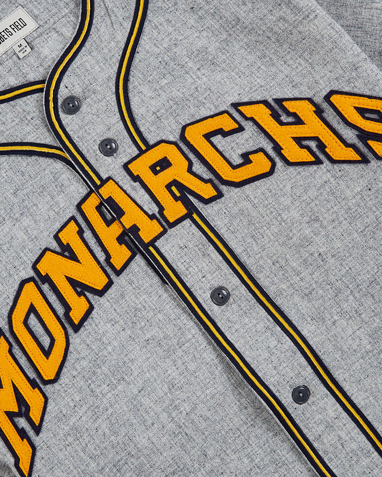 The EFF Kansas City Monarchs 1945 Authentic Wool Road Baseball Jersey features gray wool, black buttons, black and yellow trim, and MONARCHS in large yellow letters with black outline—a tribute to the iconic Negro Leagues jersey.