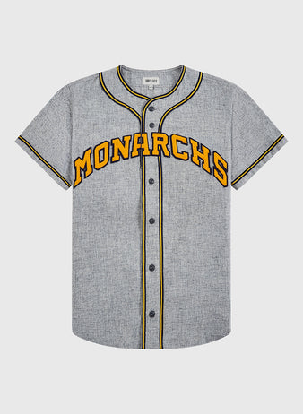 The EFF Kansas City Monarchs 1945 Authentic Wool Road Baseball Jersey features gray wool, black and yellow trim, black buttons, and bold yellow MONARCHS lettering with a black outline across the chest.
