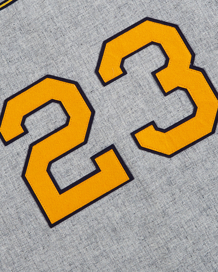 Close-up of the number 23 in large yellow font with black outline, sewn onto gray fabric on an EFF Kansas City Monarchs 1945 Authentic Wool Road Baseball Jersey.