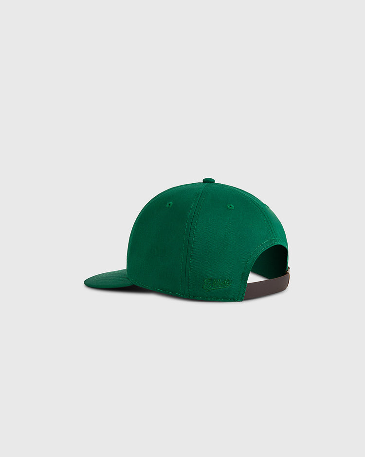 A Cienfuegos Elefantes Cotton Twill Ballcap by Ebbets Field in green, shown from the back left, features a curved brim, stitched panels, and an adjustable dark brown strap with metal clasp. Background is plain light gray.