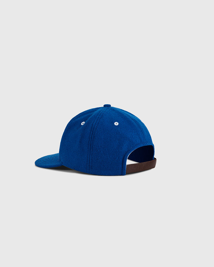 The Almendares Alacranes 1947 Authentic Wool Ballcap by Ebbets Field is shown from the back, with a royal blue crown and white eyelets, curved brim, adjustable brown strap, and a light gray background.