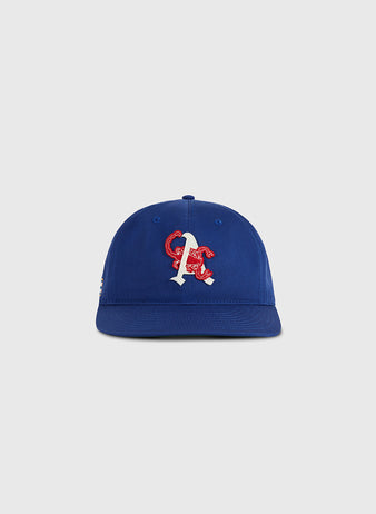 The Ebbets Field Almendares Alacranes Cotton Twill Ballcap is a vintage blue cap with a white and red embroidered “A” and red snake on the front, inspired by Cuban baseball hats. Shown on a plain light gray background.