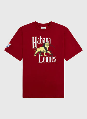 The Ebbets Field Habana Leones Short Sleeve Graphic Tee – Cuban League is a red shirt with white “Habana Leones” text, a yellow lion graphic on the front, and a blue, white, and red patch on the left sleeve honoring the Cuban League team.