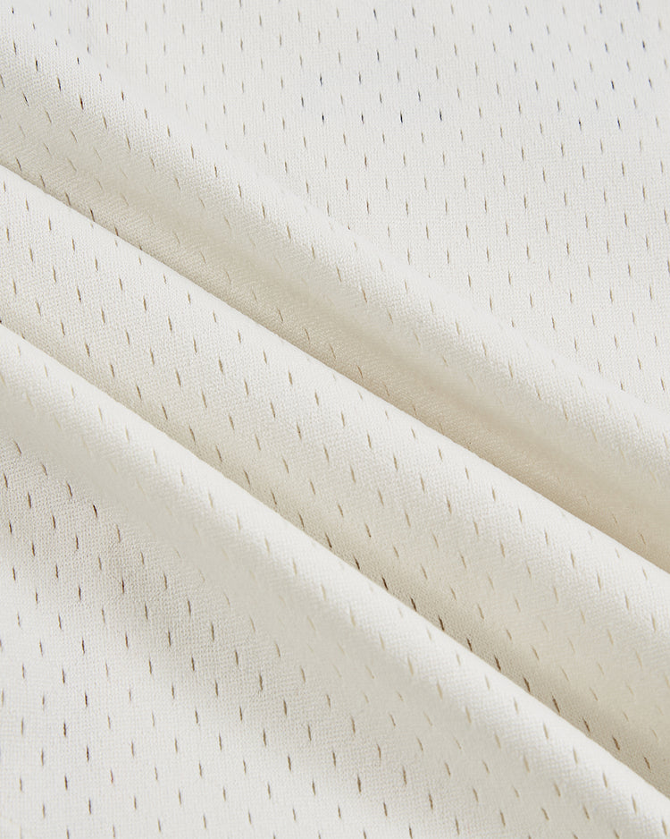 Close-up of the Ebbets Field Havana Cubans Mesh Baseball Jersey’s white fabric, featuring small, evenly spaced perforations and diagonal folds for a vintage look with soft texture and subtle pattern.