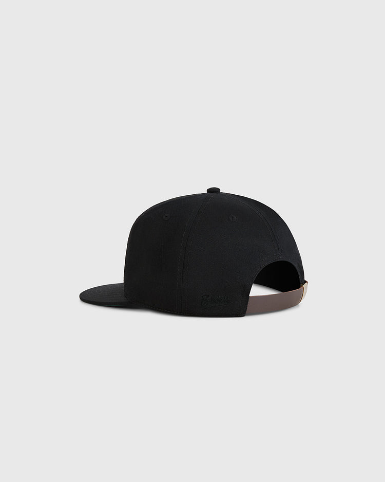 A Guinness Extra Stout Patch Cotton Twill Ballcap by Ebbets Field is shown from the back with a brown adjustable strap and curved brim, displayed on a plain light gray background.