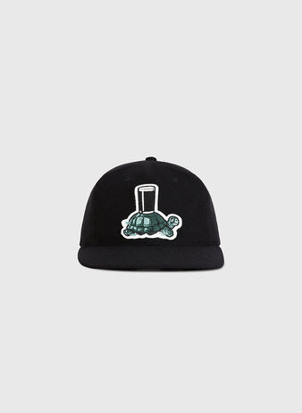 The Guinness Tortoise Authentic Wool Ballcap by Ebbets Field features an embroidered green turtle with a tall glass on its shell, centered on the front, displayed against a plain light gray background.