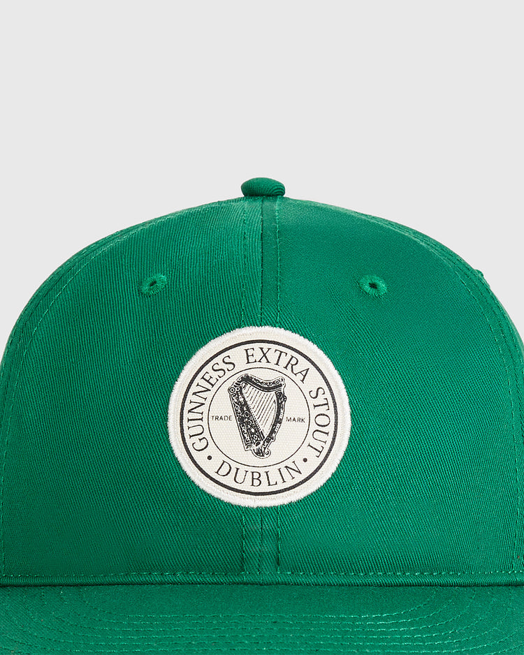 The Guinness Extra Stout Patch Cotton Twill Ballcap by Ebbets Field is a green cotton twill cap with a circular harp patch and 