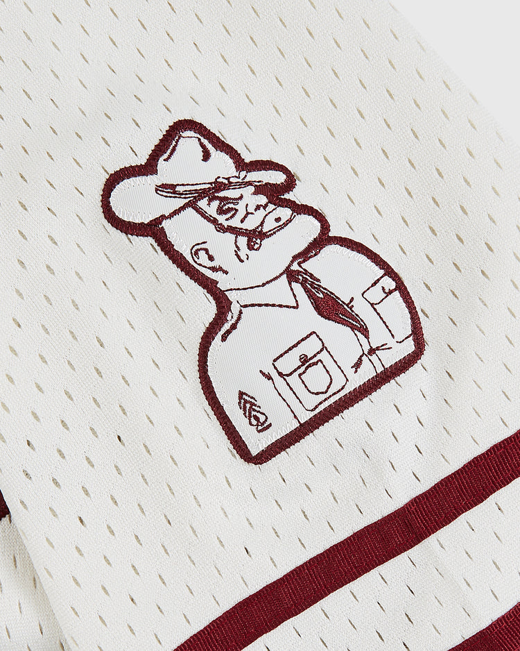 The Ebbets Field Texas A&M University 1952 Mesh Baseball Jersey features white mesh with maroon trim and an embroidered stern mascot, capturing vintage Aggies spirit with badge, sleeve stripes, and wide-brimmed hat details.