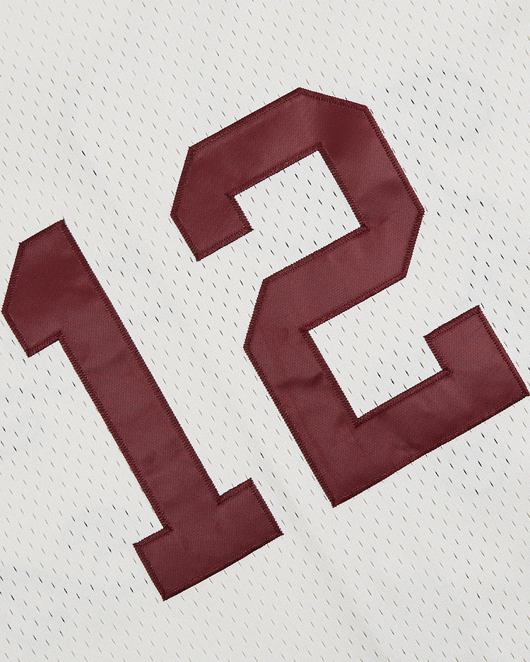 A close-up of the Ebbets Field Texas A&M University 1952 Mesh Baseball Jersey, showcasing large maroon number 12 on white mesh, inspired by the classic Aggies design.