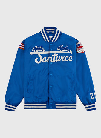 The Ebbets Field Santurce Cangrejeros Cotton Lined Satin Varsity Jacket is blue with white team lettering, chest embroidery, striped ribbed cuffs and collar, a 21 patch on one sleeve, and a Puerto Rican baseball flag patch on the other.