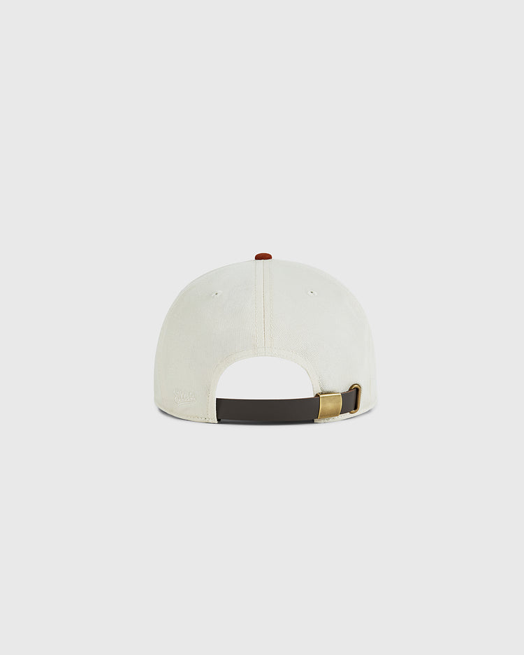 The University of Texas 1975 Cotton Twill Ballcap by Ebbets Field is shown from the back, displaying its cream cotton twill fabric and an adjustable dark brown strap with a brass buckle against a plain light background.