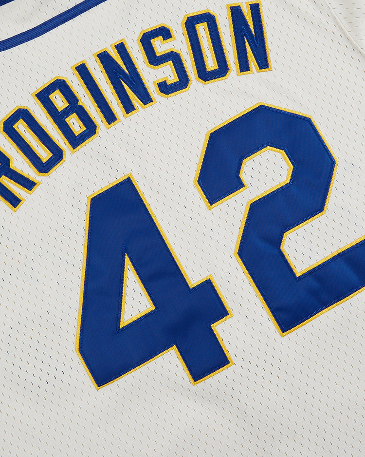 A close-up of the Ebbets Field Jackie Robinson Comic Book Hero Mesh Baseball Jersey, featuring blue and gold trim, ROBINSON name, and large blue 42—a tribute to breaking baseball’s color barrier.