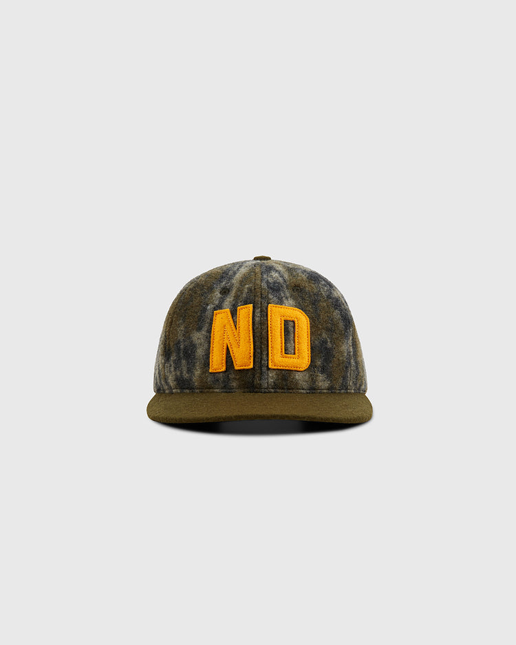 The Ebbets Field Mossy Oak x 1966 University of Notre Dame Ballcap features Bottomland camo and bold yellow ND embroidery, shown against a plain light gray background.