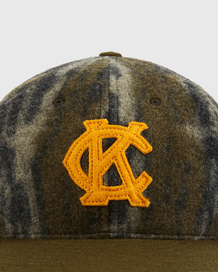 Close-up of the Ebbets Field Mossy Oak x Ebbets Field 1945 Kansas City Monarchs Ballcap, featuring Bottomland camo and a yellow embroidered KC logo—paying tribute to the classic Negro Leagues hat.