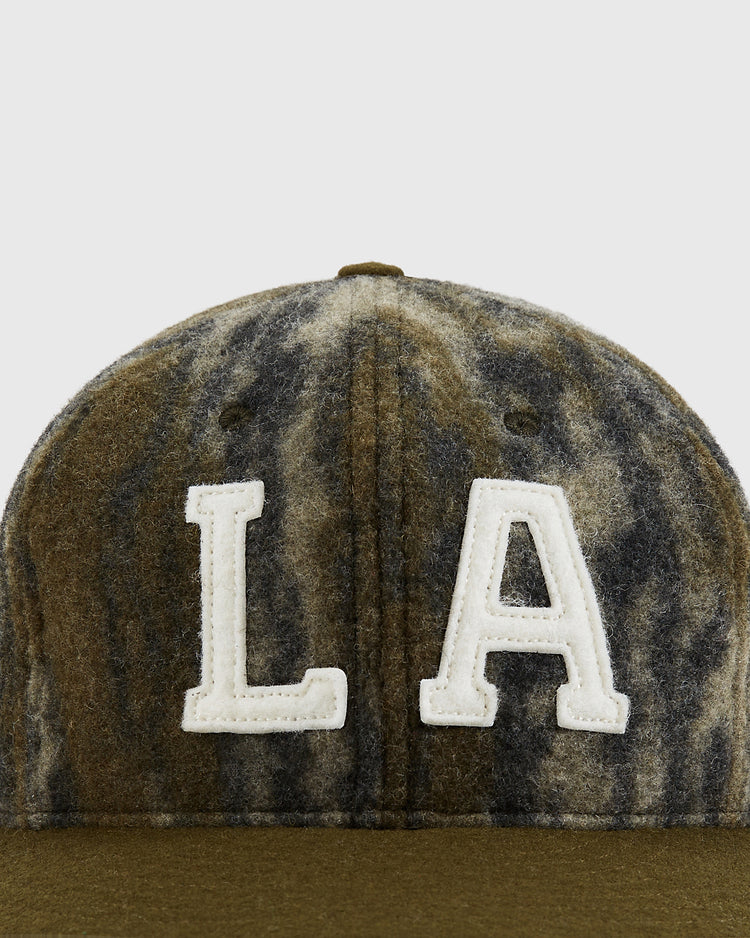 A close-up of the Ebbets Field Mossy Oak x Ebbets Field 1949 Los Angeles Angels (PCL) Ballcap, featuring brown and gray camo with bold white 