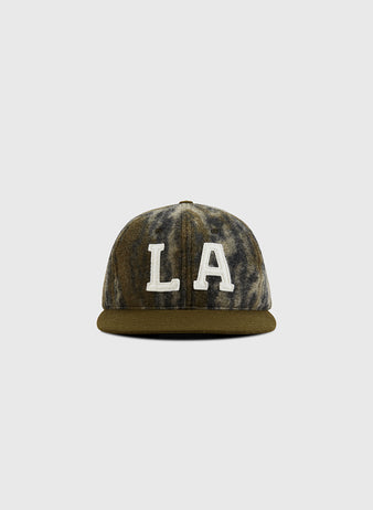 A front view of the Mossy Oak x Ebbets Field 1949 Los Angeles Angels (PCL) Ballcap, featuring a green and gray marbled design with large white 