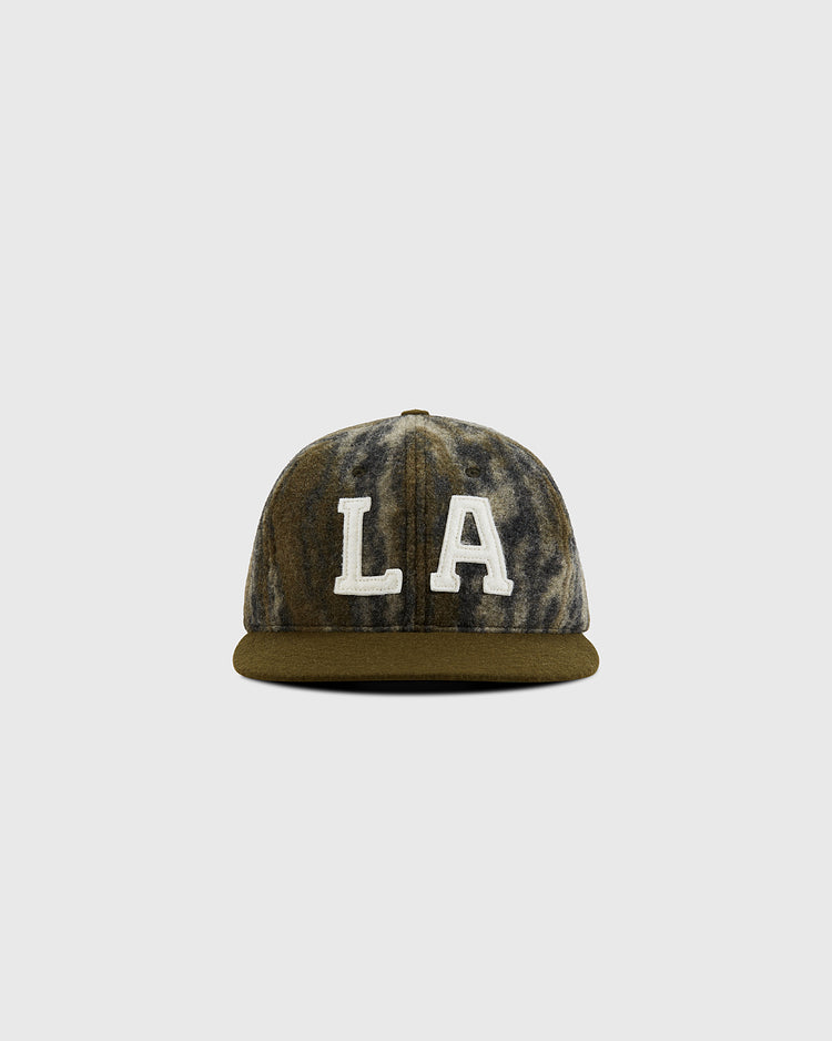 A front view of the Mossy Oak x Ebbets Field 1949 Los Angeles Angels (PCL) Ballcap, featuring a green and gray marbled design with large white 