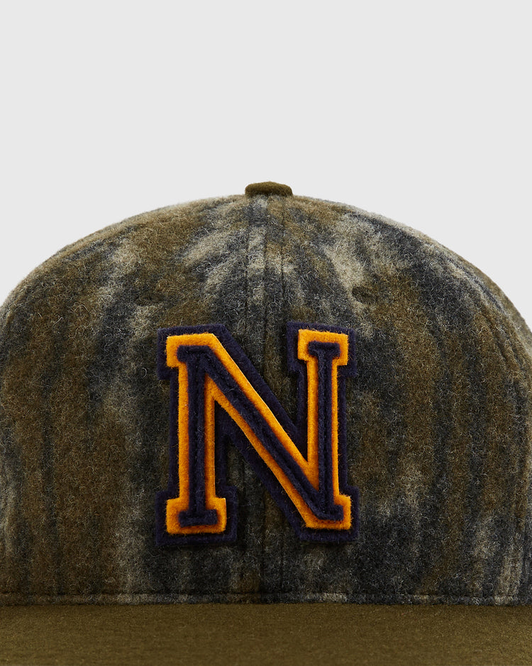The Ebbets Field Mossy Oak x Ebbets Field 1947 Navy Ballcap features classic Bottomland camo and a bold, orange-outlined letter N embroidered on the front, inspired by vintage Navy Academy ballcaps.