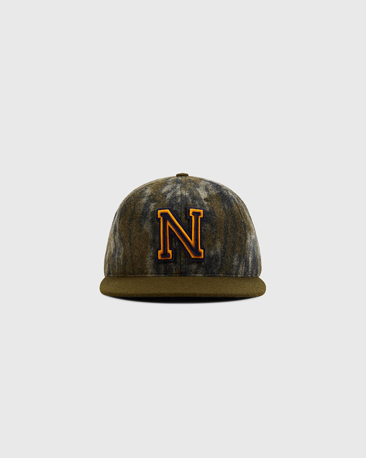 The Ebbets Field Mossy Oak x Ebbets Field 1947 Navy Ballcap features a brown and gray marbled camo pattern, a bold yellow and black 